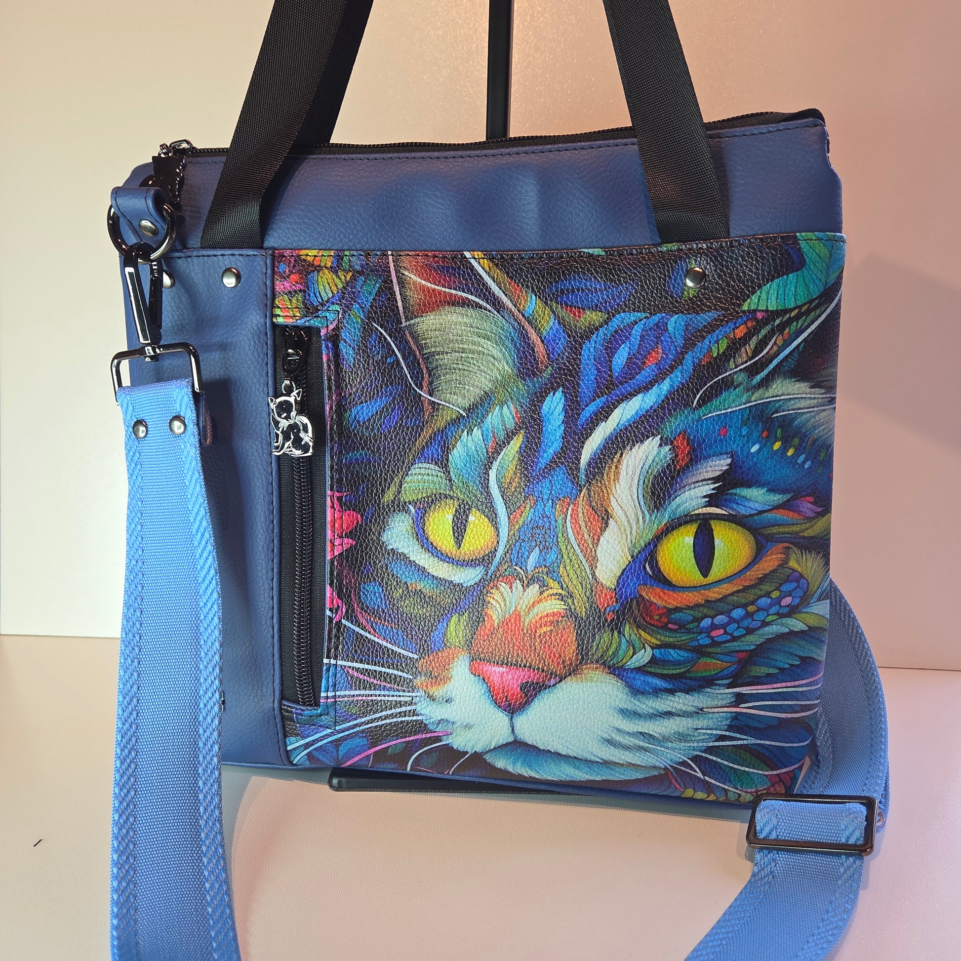 Colourful cat with striking yellow eyes design on a blue vinyl bag