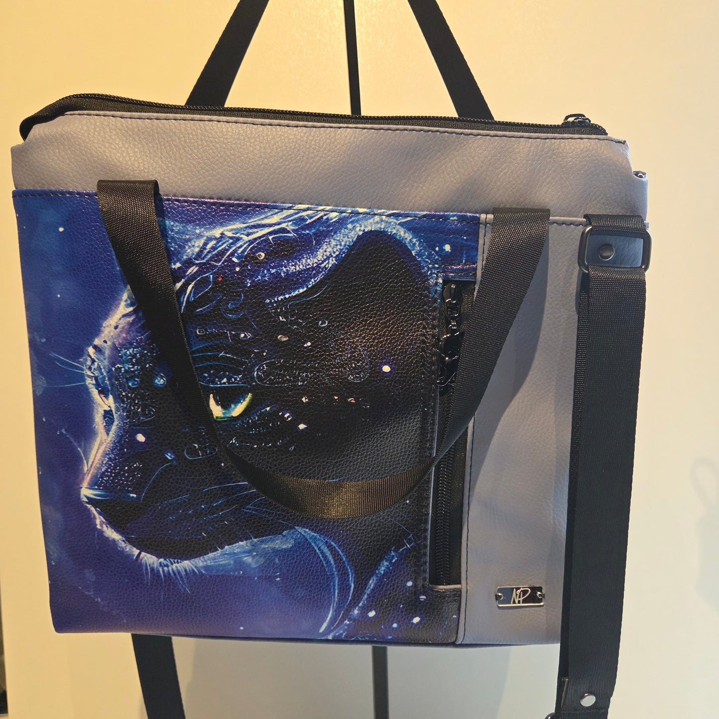 Blue bag with image of starry panther with black straps and hardware