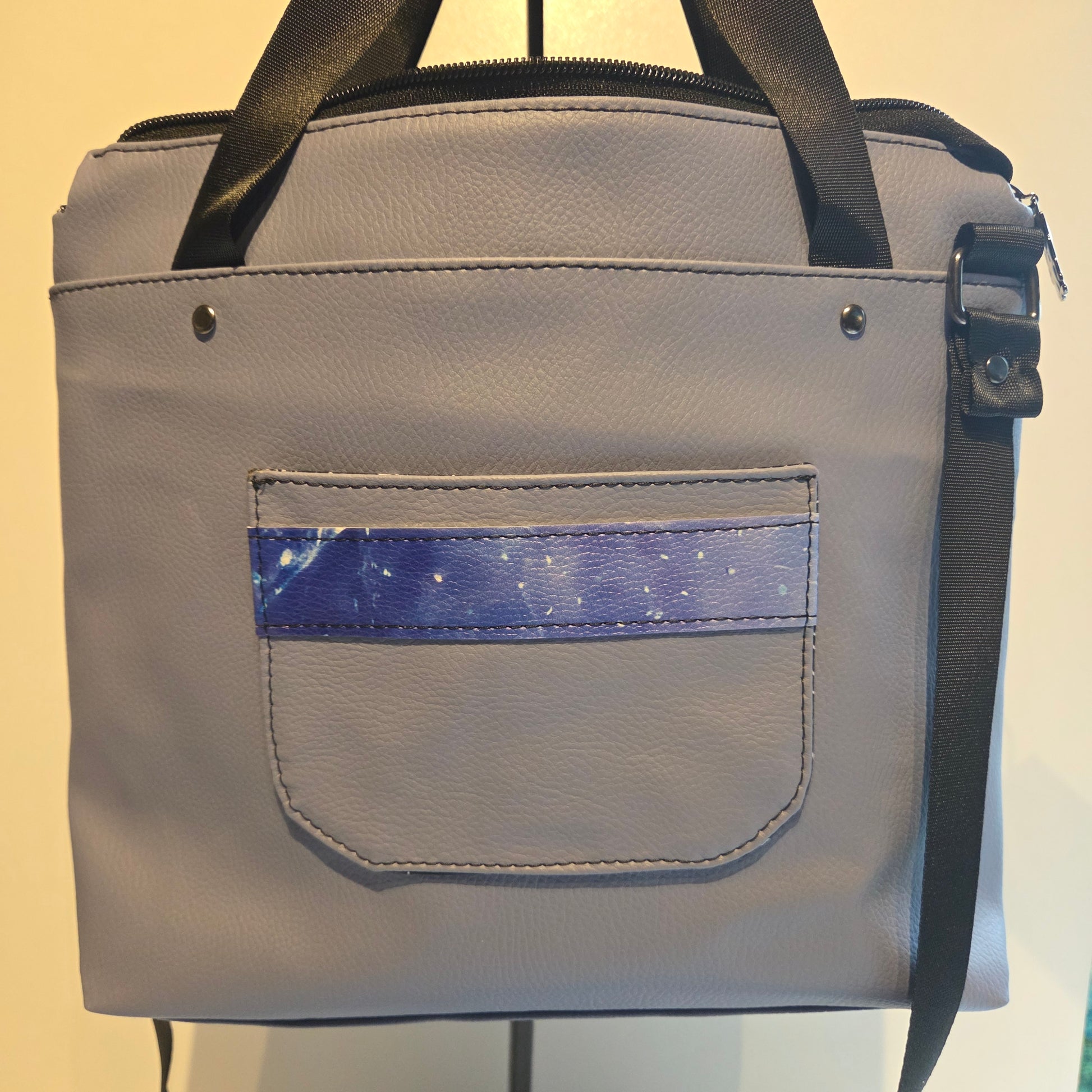 Pale blue vinyl bag showing back panel with trimmed pocket detail