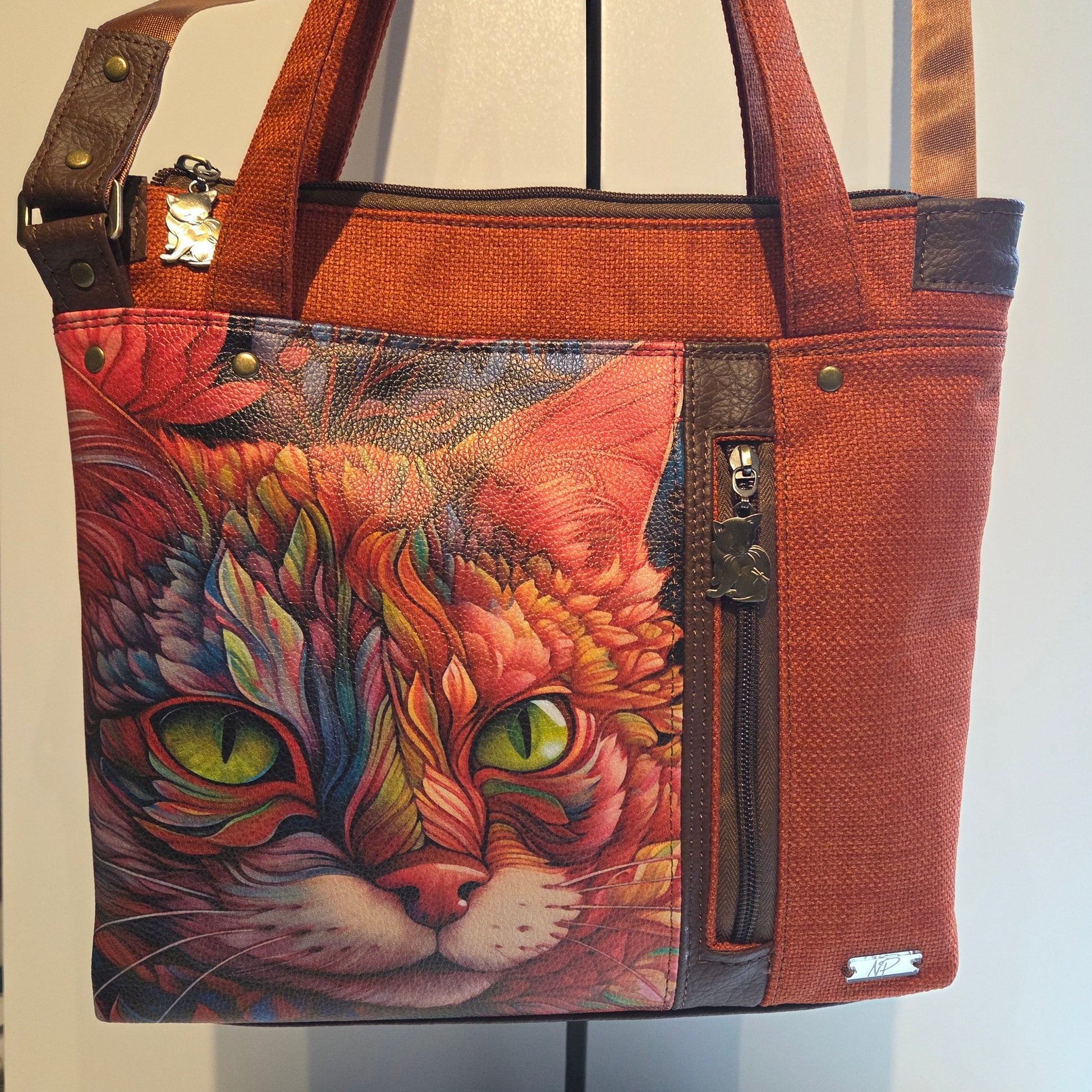 Orange bag with a colourful cat design and brown accents