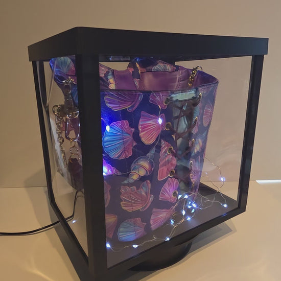 Madison Handbag inside a lit, rotating display box