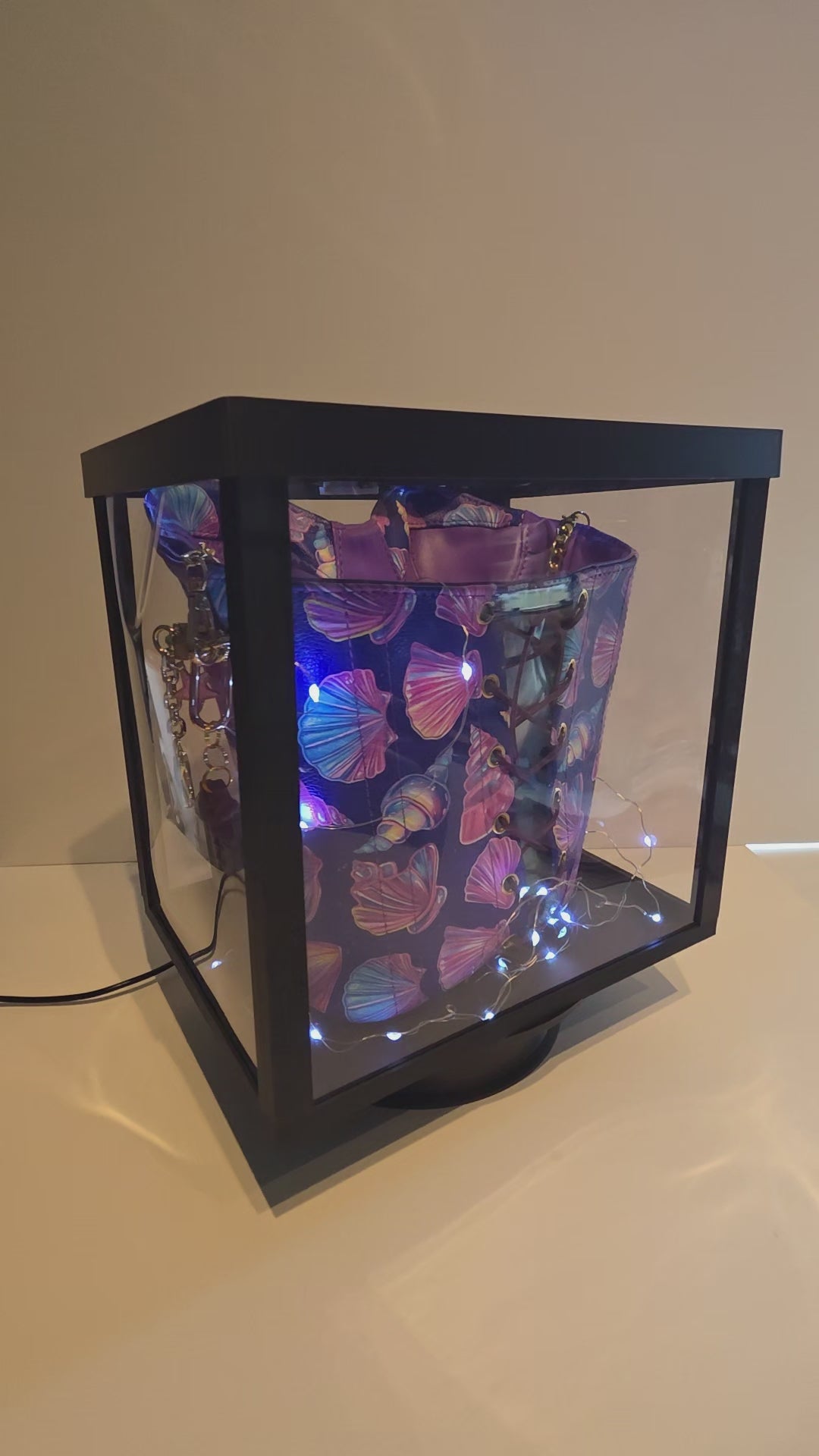 Madison Handbag inside a lit, rotating display box